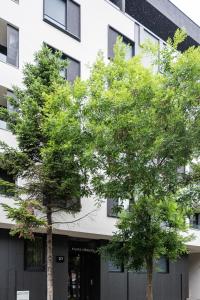 two trees in front of a building at VERTIGO One Bedroom apartment - Free private parking-Fast WI-FI in Novi Sad