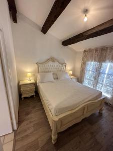 um quarto com uma grande cama branca com duas mesas de cabeceira em Maison du Cloitre Couvent des Carmes em Narbona