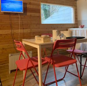 a table with four chairs and a television in a room at Casa Turchina in Vernante