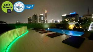 una piscina en la azotea de un edificio por la noche en The Victory Residences Bangkok, en Bangkok