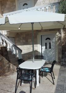 a table and chairs under an umbrella on a patio at Apartman Copacabana in Krašići