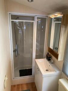 een badkamer met een douche en een wastafel bij Chalet Olm 29 in Zoerte