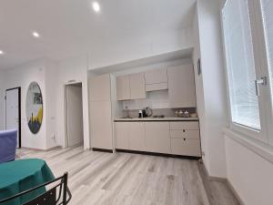 an empty kitchen with white cabinets and a green chair at La Presentosa Bed&Breakfast in Ortona