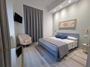 um quarto com uma cama azul e uma cadeira em La Presentosa Bed&Breakfast em Ortona