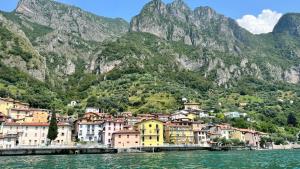 a town on the water in front of a mountain at Csendes és nyugodt hely medencével. in Parzanica