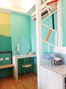 a room with a bunk bed with a desk and a mirror at 墾丁大街 皇佳旅店 in Kenting