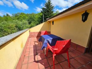 una mesa y sillas sentadas en un balcón en Hotel Rural Casa Migio en Urbiés