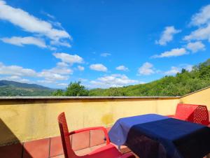 una mesa y sillas en un balcón con vistas en Hotel Rural Casa Migio en Urbiés