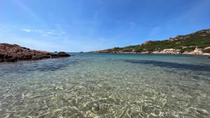 ein großer Wasserkörper neben einigen Felsen in der Unterkunft Isola Rossa Appartamenti Paduledda in Isola Rossa