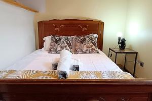 1 cama con cabecero de madera y almohadas en Le Limouxin jungle Wifi, petit balcon *Oc Keys, en Limoux
