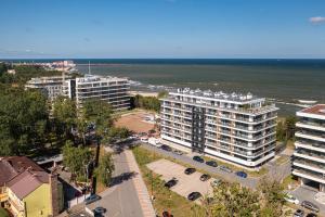 an aerial view of a city with buildings and the ocean at Solaris Darłówko Premium Emilia Strupiechowska in Darłowo