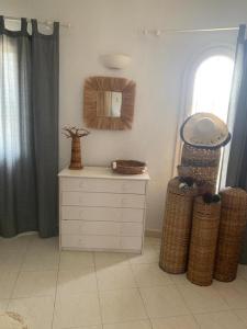 a room with a dresser and a mirror and two baskets at La Finca Blanca Javea in El Tosalet