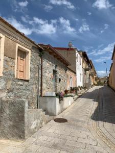 an old stone building on a cobblestone street at Isola Rossa Appartamenti Paduledda in Isola Rossa