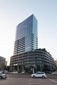 Un gran edificio con coches aparcados en un estacionamiento. en Hanza Tower Luxury, en Szczecin