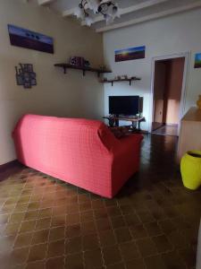 a red couch in a living room with a television at Da Luca e Simona in Camaiore
