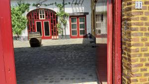 czerwone drzwi z beczką przed budynkiem w obiekcie Boerderijwoning Elsloo w mieście Elsloo