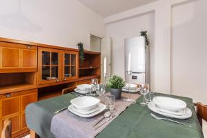 un comedor con una mesa con platos y copas de vino en Rossini Apartment, en Milán