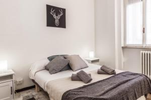 Dormitorio blanco con cama con almohadas en Rossini Apartment, en Milán