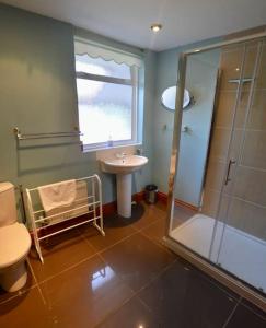 布萊克尼的住宿－Greensholme - Blakeney - Crabpot Cottages，带淋浴卫生间和盥洗盆的浴室
