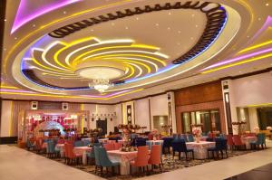 a banquet hall with tables and chairs and a ceiling at Grand Heritage Hotel & Resort in Ludhiana