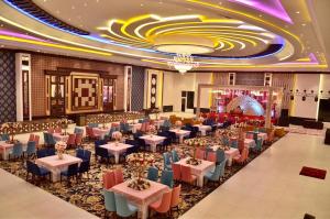 um salão de banquetes com mesas e cadeiras numa sala em Grand Heritage Hotel & Resort em Ludhiana