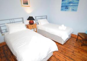 1 dormitorio con 2 camas y mesa con lámpara en Greensholme - Blakeney - Crabpot Cottages, en Blakeney