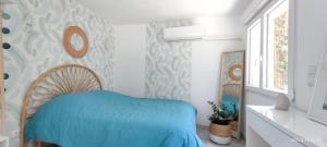a bedroom with a blue bed and a window at Belle dépendance de 30m2 avec terrasse et jardin in Villeneuve-lès-Avignon