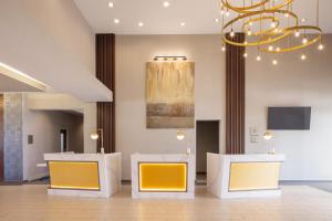 eine Lobby mit zwei gelben Stühlen und einem Kronleuchter in der Unterkunft Crowne Plaza Ft Myers Gulf Coast, an IHG Hotel in Fort Myers