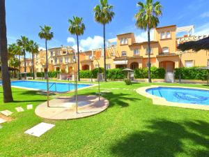 a resort yard with a swimming pool and palm trees at Casa Altamar I Javea - 5009 in Jávea