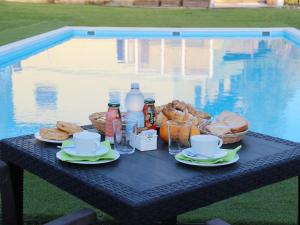 a picnic table with food and drinks on it next to a pool at Country & Beach B&B in Capoterra