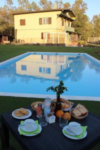 a table with food on it next to a swimming pool at Country & Beach B&B in Capoterra