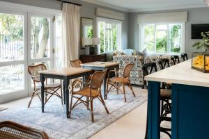 a living room with tables and chairs and a couch at The Belmont in Franschhoek