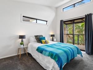 a white bedroom with a bed and a window at Top of the Bay in Arthurs Seat