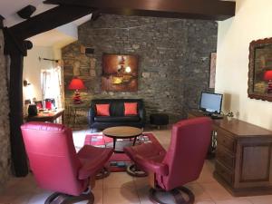 普萊桑斯的住宿－木蘭酒店，客厅设有粉红色的椅子和石墙
