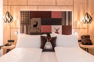 a bedroom with a white bed with white pillows at Helmhotel in San Candido