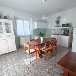 a kitchen with a wooden table and some chairs at Da Luca e Simona in Camaiore