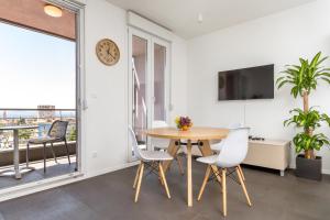 a dining room with a table and chairs and a large window at Nest Apartment in Split