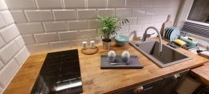 a kitchen with a sink and a wooden counter top at uniquechambre Gdynia in Gdynia