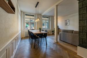 - une salle à manger avec une table, des chaises et un canapé dans l'établissement Historische Wohnung im Herzen der Thuner Altstadt, à Thun