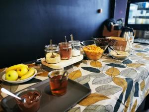 uma mesa com comida e bebidas numa toalha de mesa colorida em Auberge de Jeunesse de Morlaix em Morlaix