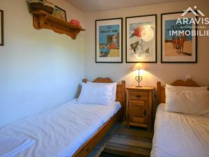 a bedroom with two beds and a table with a lamp at Appartement Le Grand-Bornand, 3 pièces, 4 personnes - FR-1-391-5 in Le Grand-Bornand