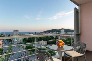 a balcony with a table and chairs and a view of a city at Nest Apartment in Split