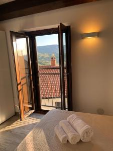 a bedroom with two towels on a bed with a window at Vianova in Pietrapertosa