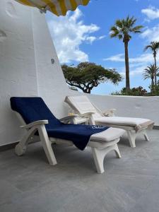 a couple of chairs sitting on a patio at Apartamento Puerto Rico - Primera línea de playa in Mogán