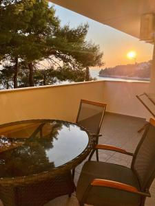 a table and chairs on a balcony with the sunset at Apartments Domani in Omiš