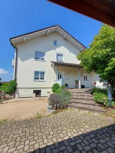 a large white house with a brick driveway at Ferienwohnung Wenzl in Schnaitsee