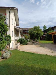 a house with a gravel driveway next to a yard at Ferienwohnung Wenzl in Schnaitsee