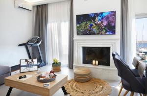 a living room with a fireplace and a tv on the wall at Azura View Foinikas in Finikas