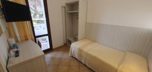 a hotel room with a bed and a television at Hotel Mon Repos in Baja Sardinia