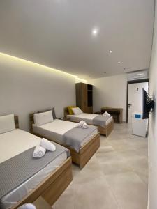 a hotel room with three beds and a television at Lori Gardenia Hotel in Stjar +13 photos